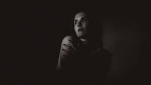 A dramatic black and white portrait with moody lighting creates a film noir atmosphere.