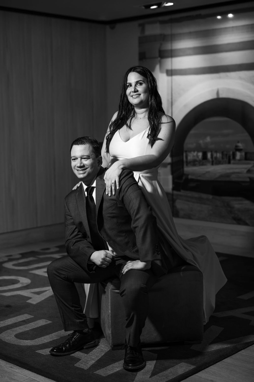 A black and white portrait of a couple posing in an elegant hotel setting.