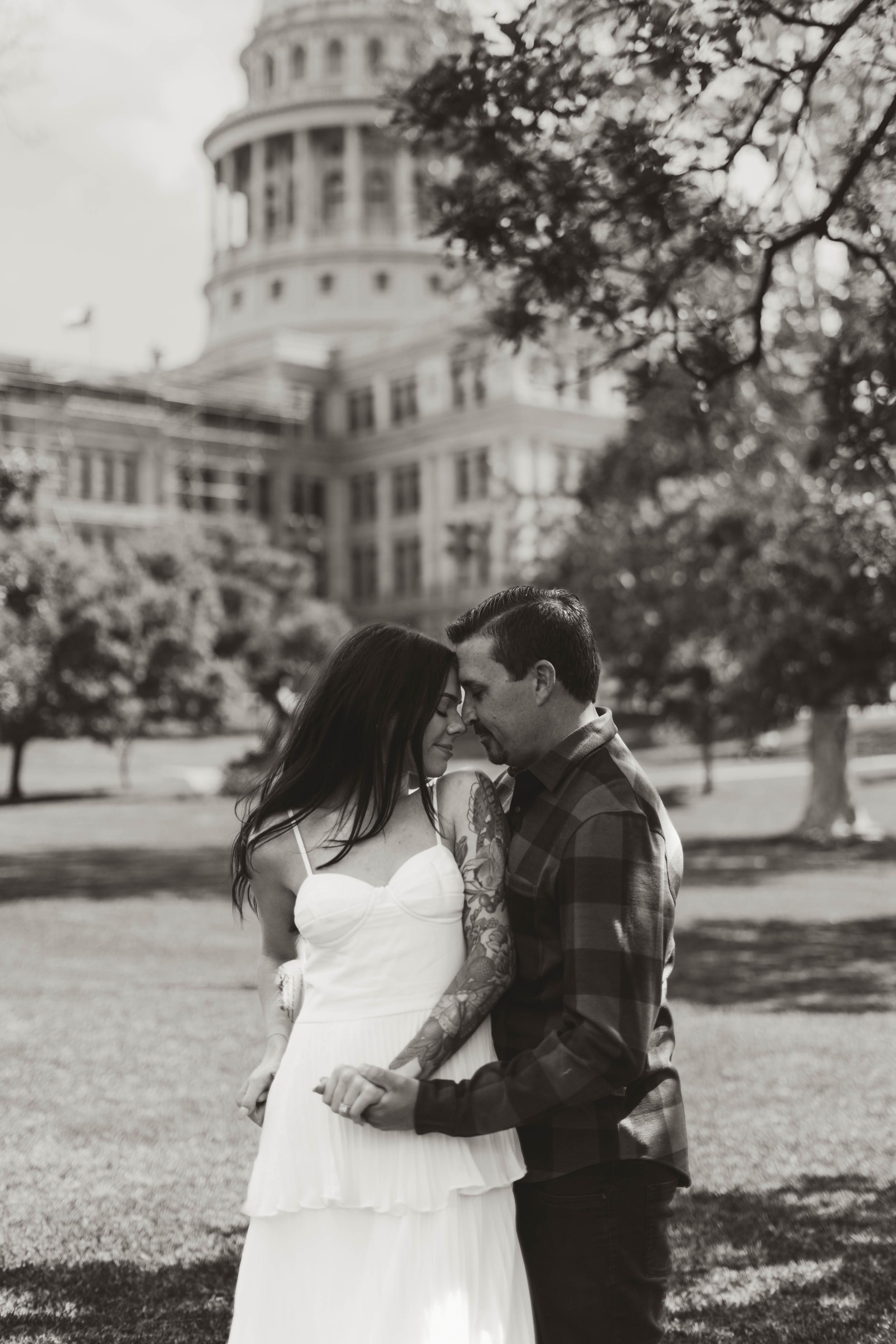 Black and white romantic moment captured in front of Texas State Capitol.
