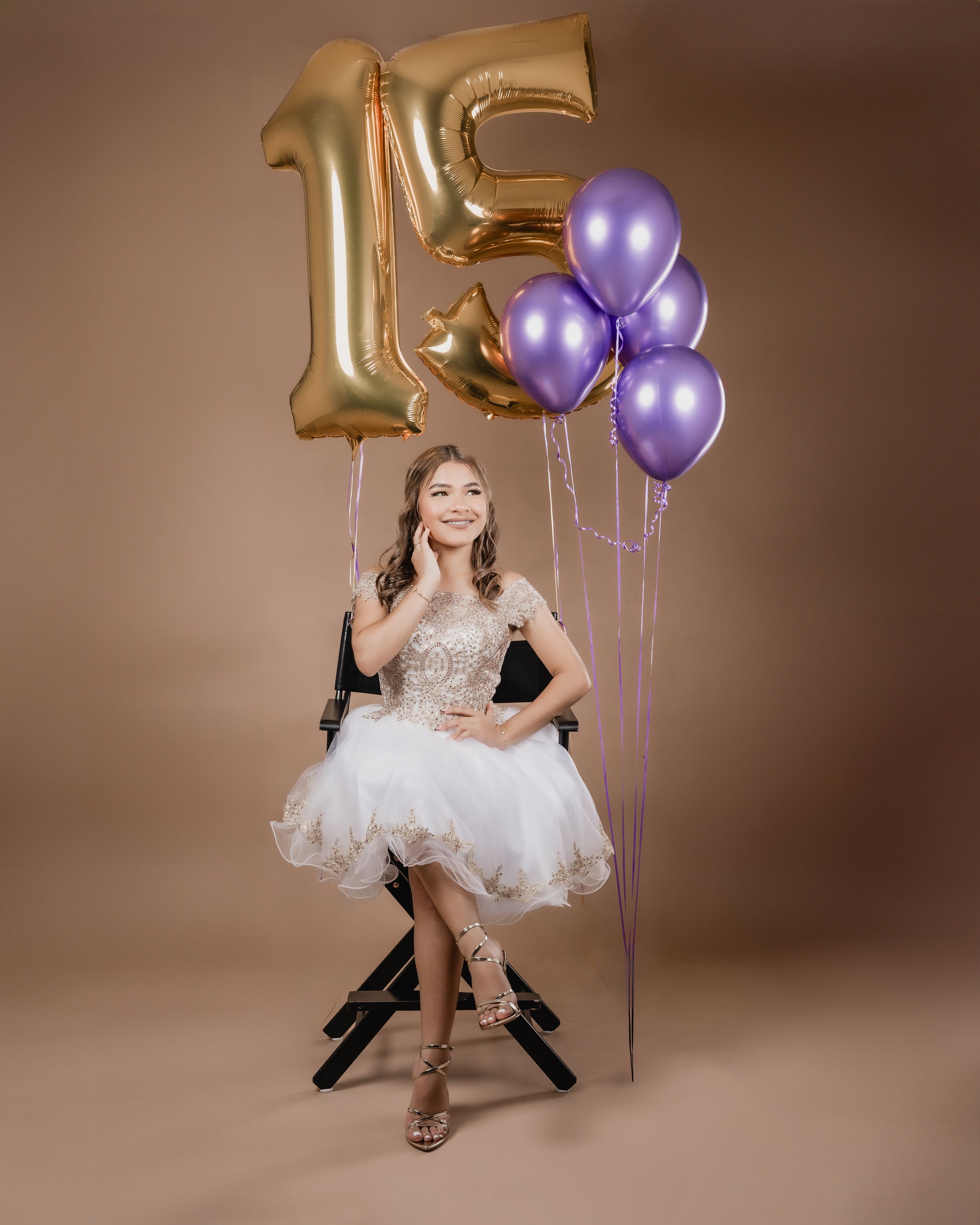 Celebratory portrait with gold number 15 balloon and purple accent balloons.