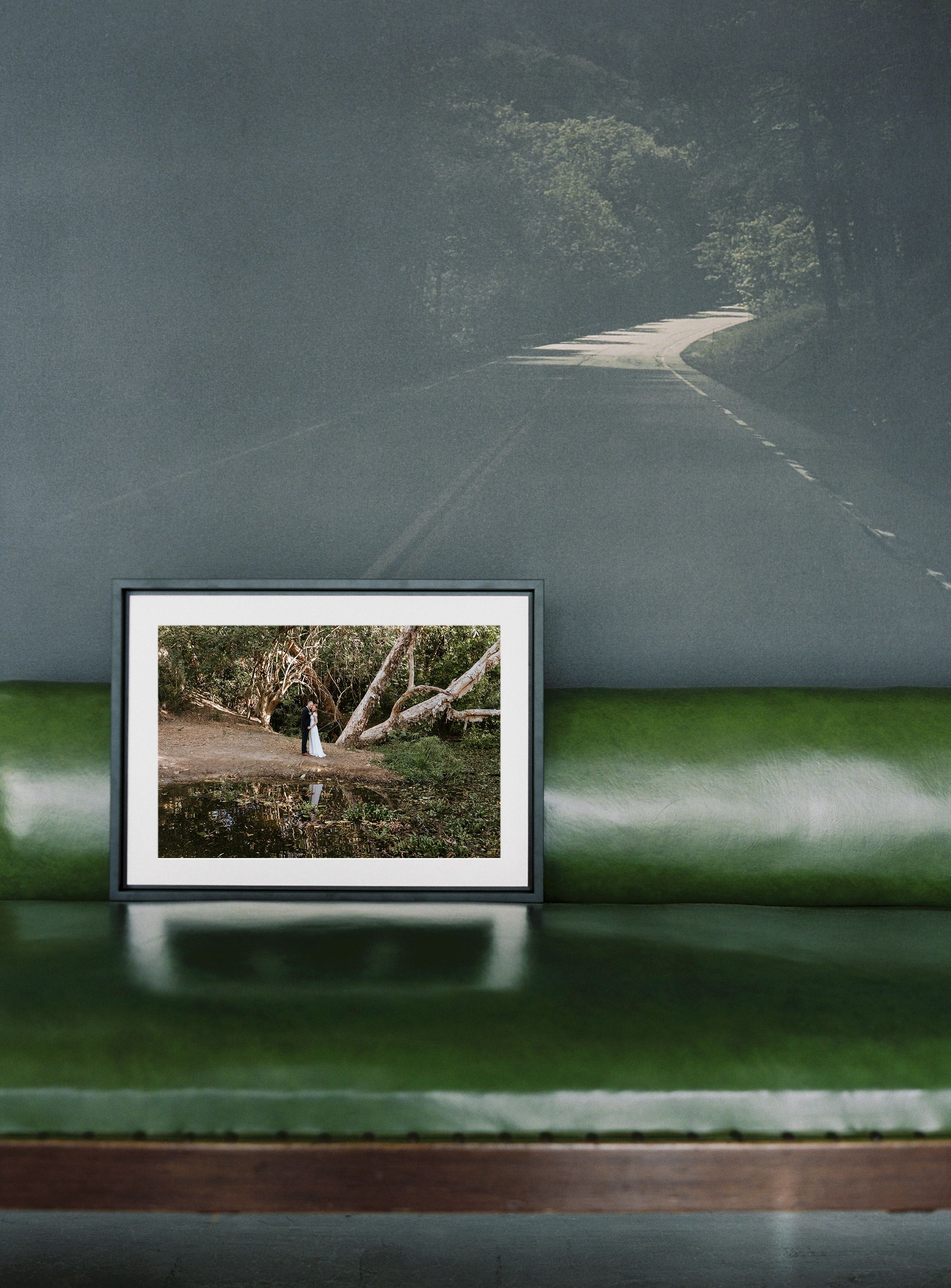 A framed nature photograph displayed on a green leather seat inside what appears to be a car or vehicle interior.