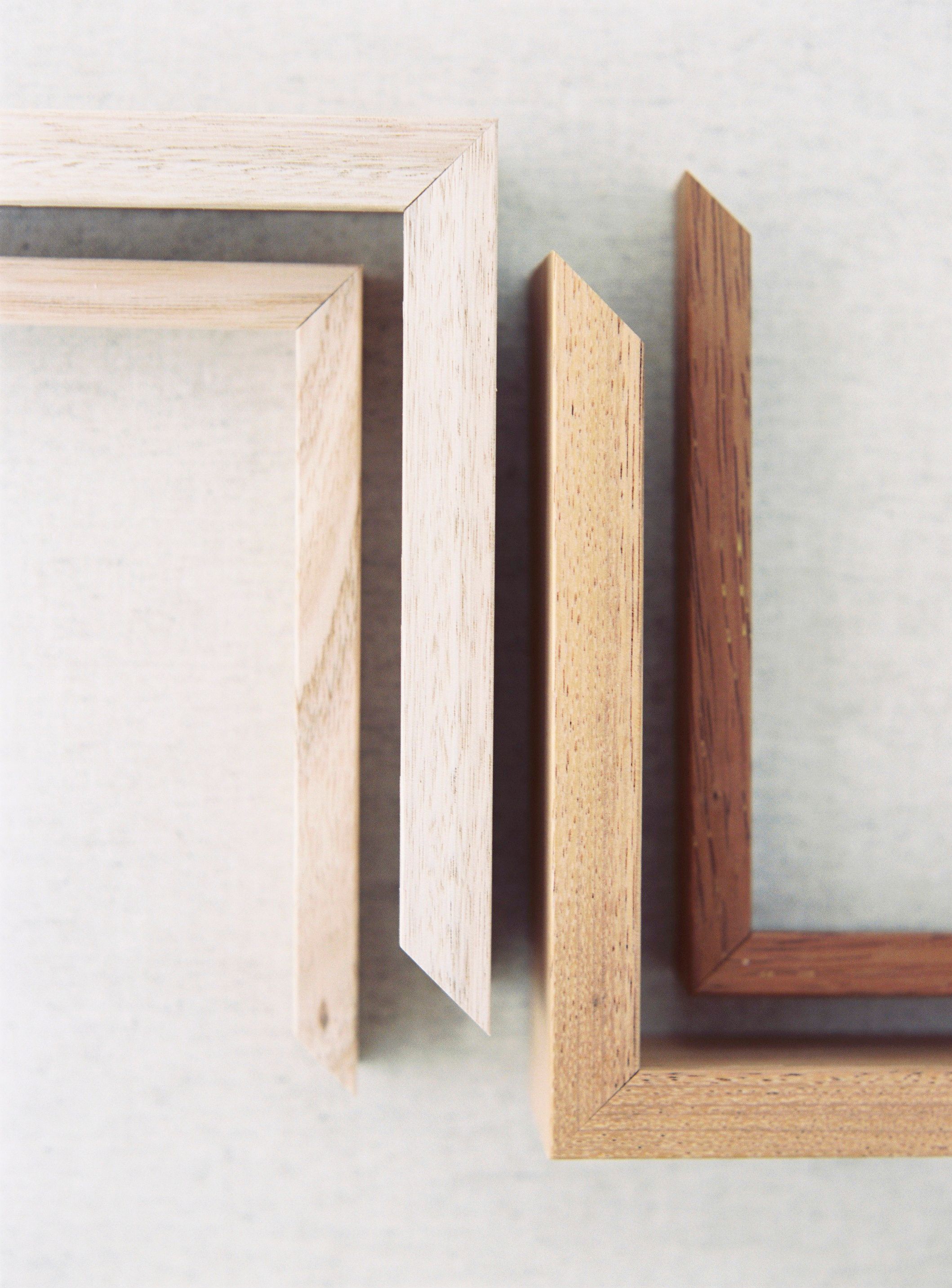 Assorted wooden picture frame corners displayed on light background.