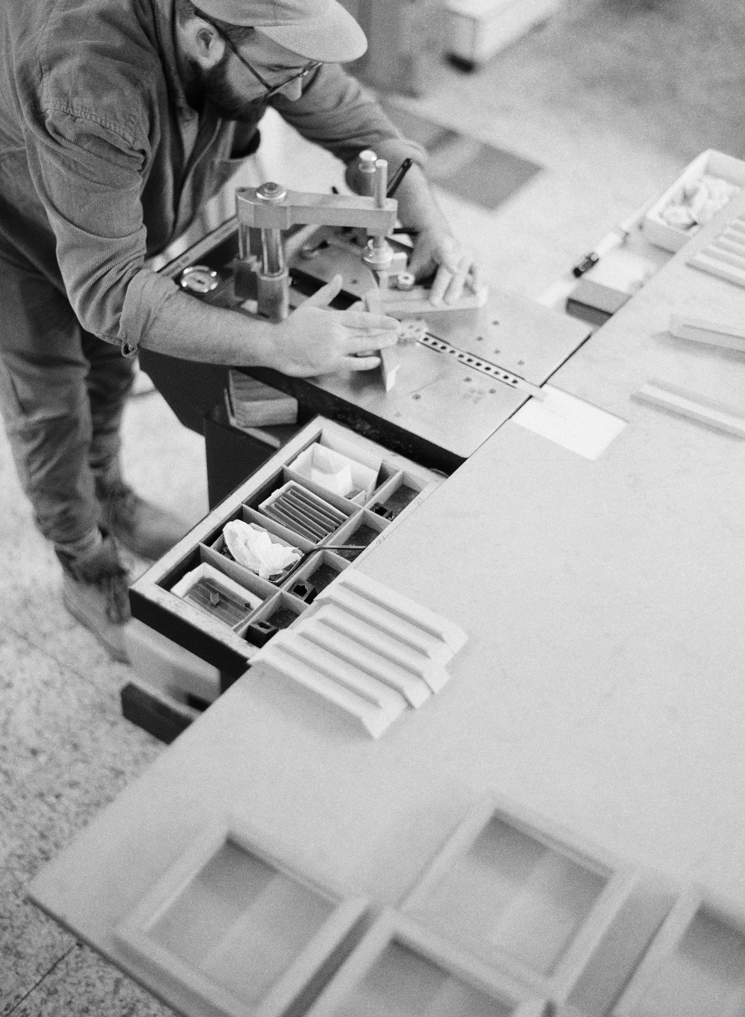 Black and white image of hands working on photo album assembly.