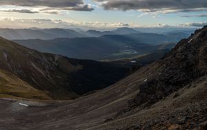 Panoramic view of mountain valleys and ridges under dramatic cloudy skies.