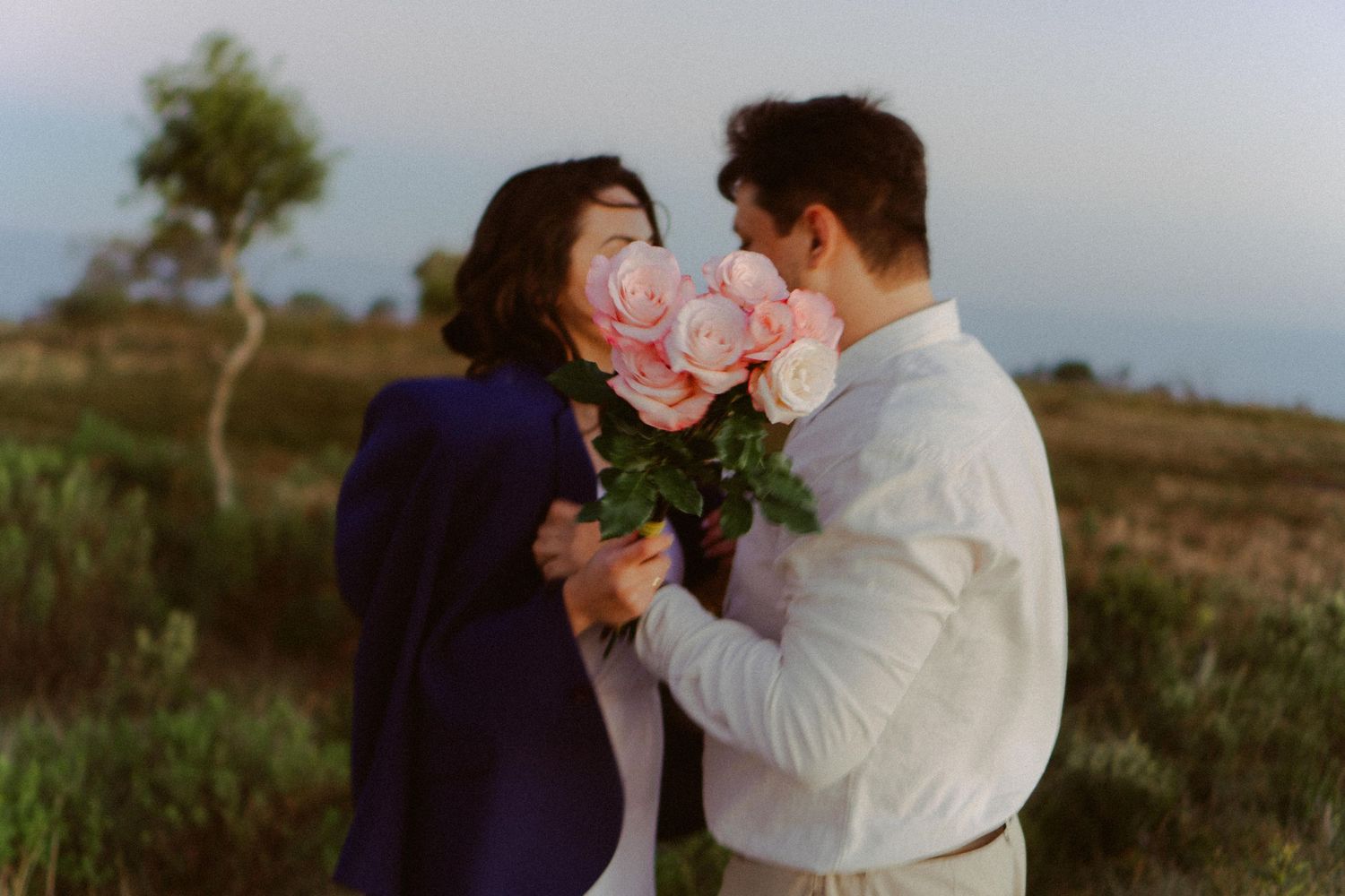 Casal se olha por trás de um buquê de flores em Campos do Jordão © Clara e Matheus Fotógrafos de Casamentos
