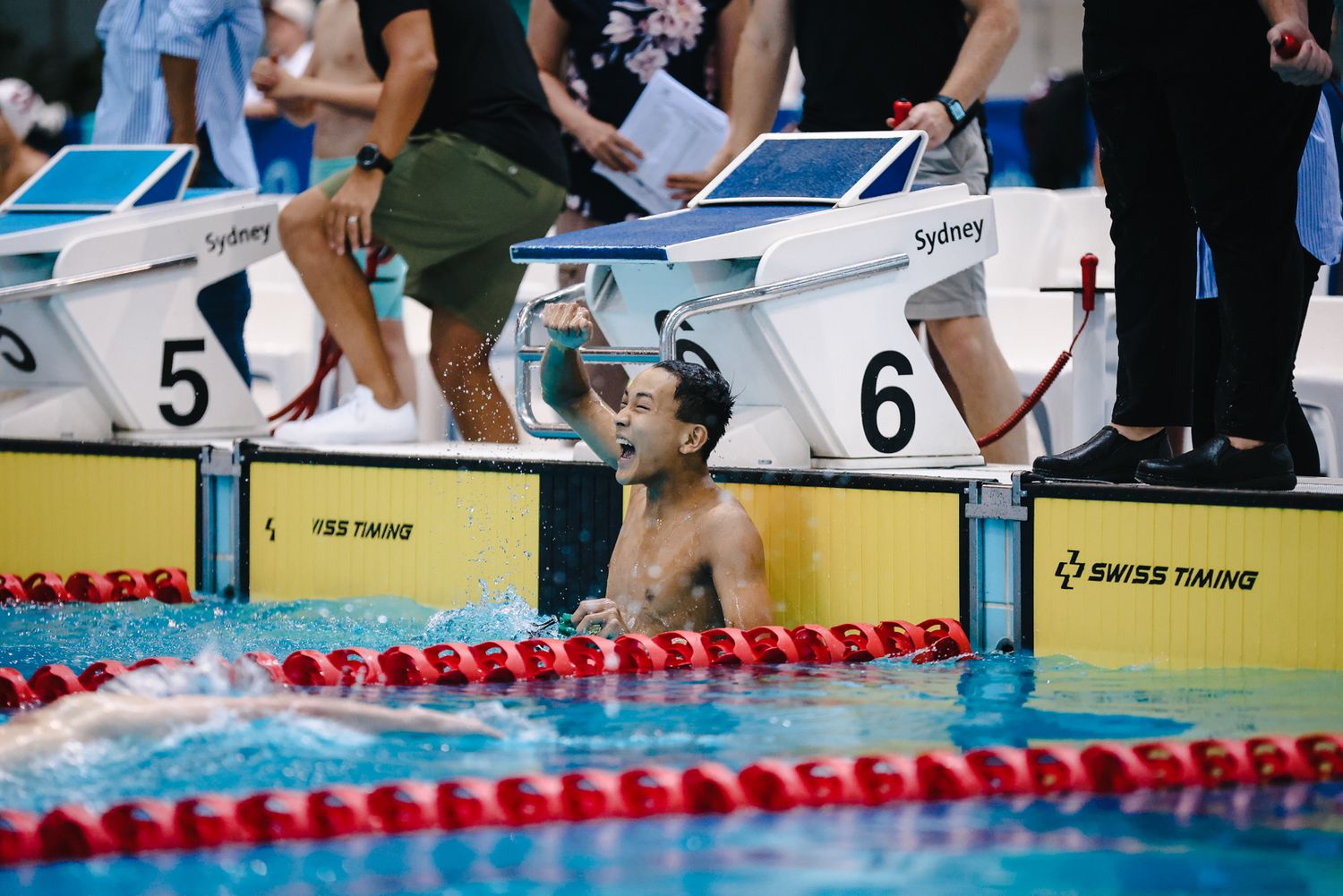 Swimmer celebrates victory in swimming pool during competition.