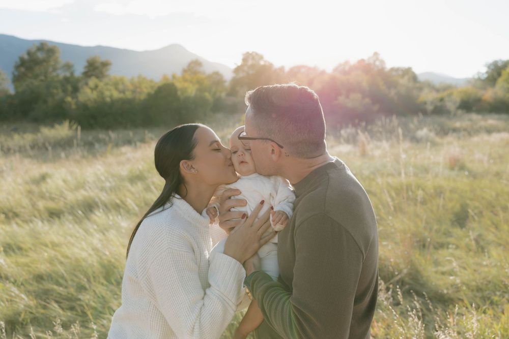 Romantic couple sharing tender moments in a sunlit meadow during golden hour.