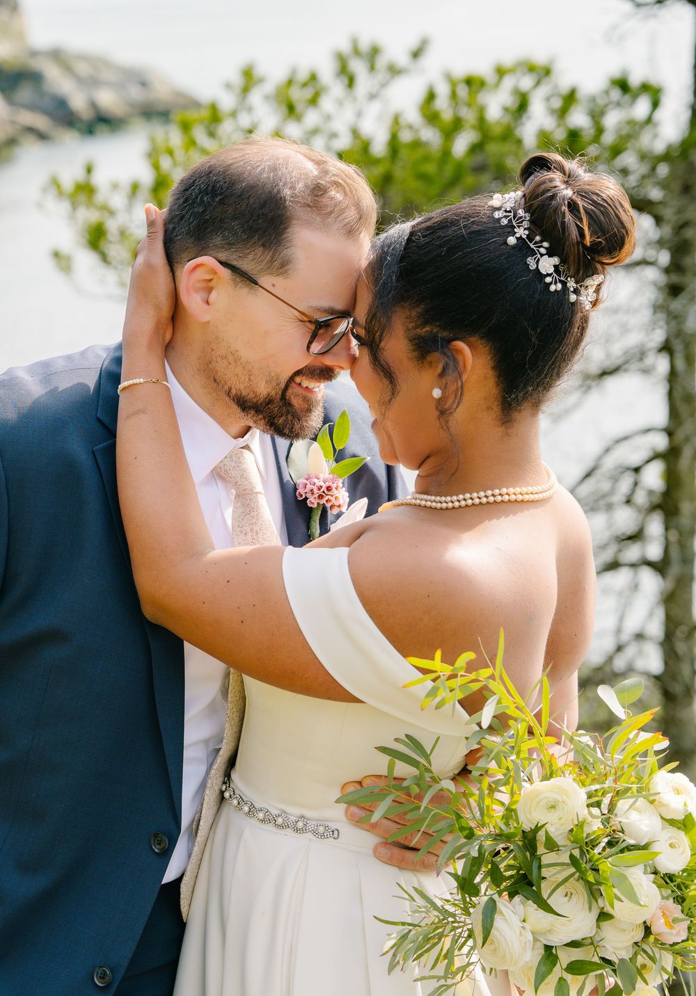A couple shares an intimate moment during their outdoor wedding with a stunning natural landscape backdrop.