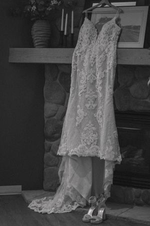 Timeless black and white photo of a wedding dress, elegantly displayed with flowing fabric and classic silhouette.