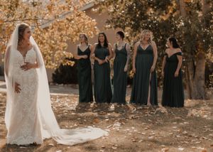 Bride preparing for the first look moment, gazing back at her bridal party during a fall wedding.