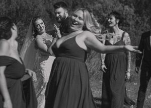 Trendy blurred shot of a bridal party walking around a couple, captured in striking black and white.