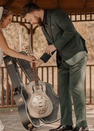 Bride gifts a guitar to the groom, capturing a special candid moment filled with joy and love.