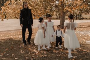 Family of the bride, featuring children in white dresses and brother-in-law, captured in a joyful moment.