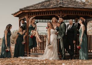 Trendy wedding party poses around a gazebo, exuding stylish, Vogue-like vibes.