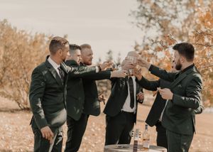 Groomsmen raising glasses for a toast, celebrating camaraderie and joy before the wedding.