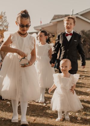 Kids of wedding party walking down the aisle, filled with joy and excitement as they approach the altar.