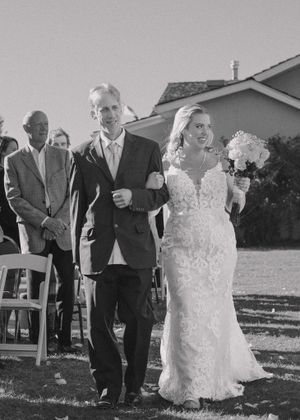 Bride and father of bride walking down the aisle, filled with joy and excitement as they approach the altar.