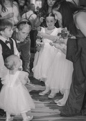 Kids enjoying the reception with the father of the bride, captured in a candid black and white moment.