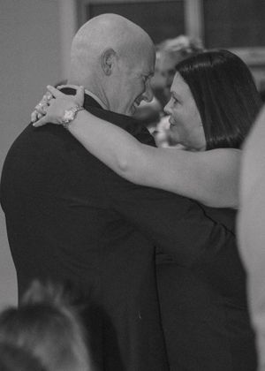 Close-up of the father and mother of the bride dancing together, captured in timeless black and white.