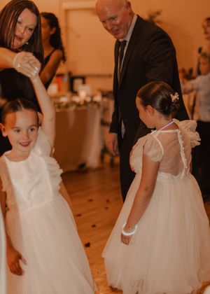 Father and mother of the bride dancing with kids at the wedding, capturing joyful moments in vibrant color.