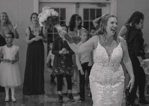 Bride getting ready to toss her bouquet, captured in timeless black and white.