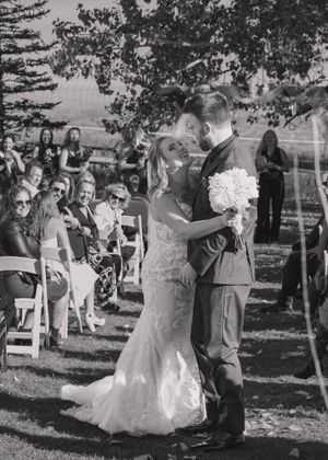 Black and white photo of bride and groom walking down the aisle together as a newly married couple.
