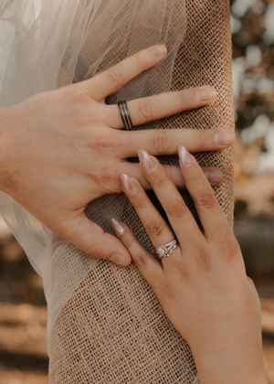 Close-up of bride and groom's hands with wedding rings, symbolizing their union and love.
