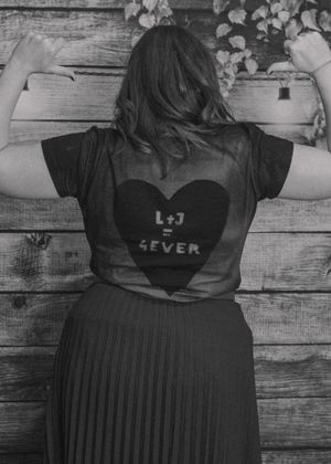 Wedding guest wearing a T-shirt showcasing bride and groom's initials and 'Forever' in a heart.