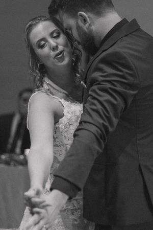 Joyful bride and groom dance together, showcasing their happiness and love in a candid moment on the dance floor.