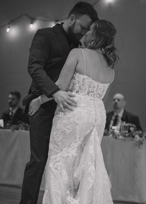 Classic black and white photo of bride and groom embracing during their first dance, capturing a timeless moment.