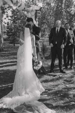 Bride and groom sharing their first kiss, captured in timeless black and white.