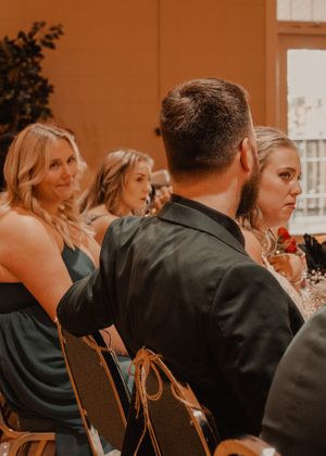 Candid shots of the bride and groom with the wedding party during speeches.