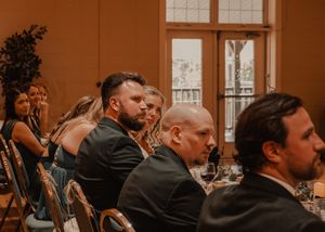 Candid shots of the bride and groom with the wedding party during speeches.
