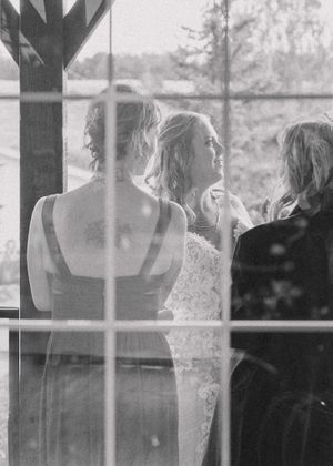 candid shot bride and bridesmaids through a window, shot in timeless black and white,