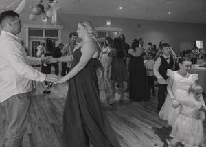 Wedding reception guests dancing joyfully captured in black and white.