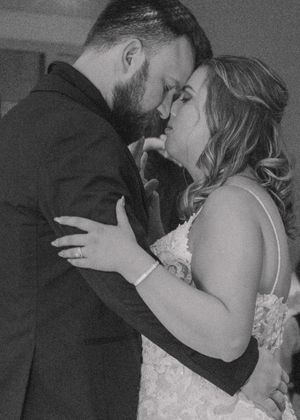 Close-up of bride and groom embracing in a heartfelt moment, black and white.