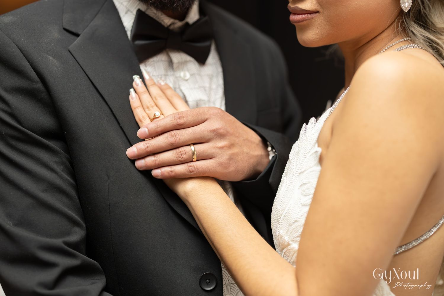 Close-up detail shot of hands touching on formal attire.