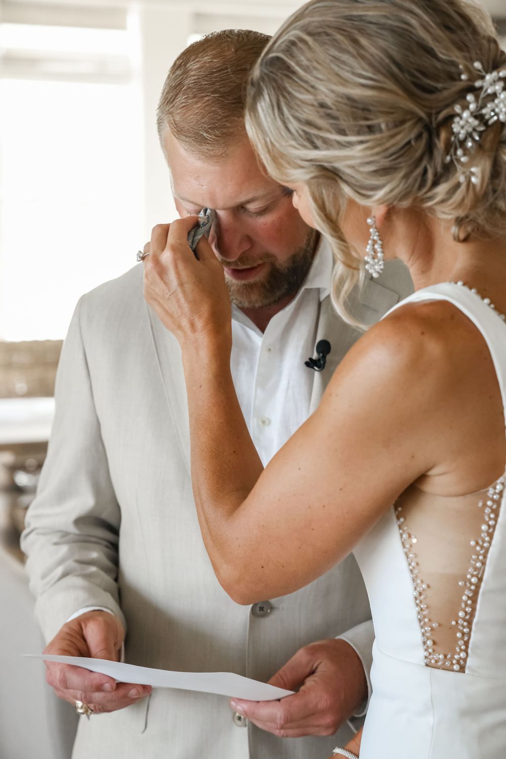 An emotional private moment between a couple reading a letter on their wedding day.