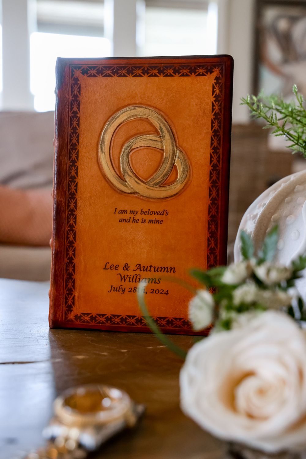 Brown leather wedding album with Celtic knot design and personalized inscription.