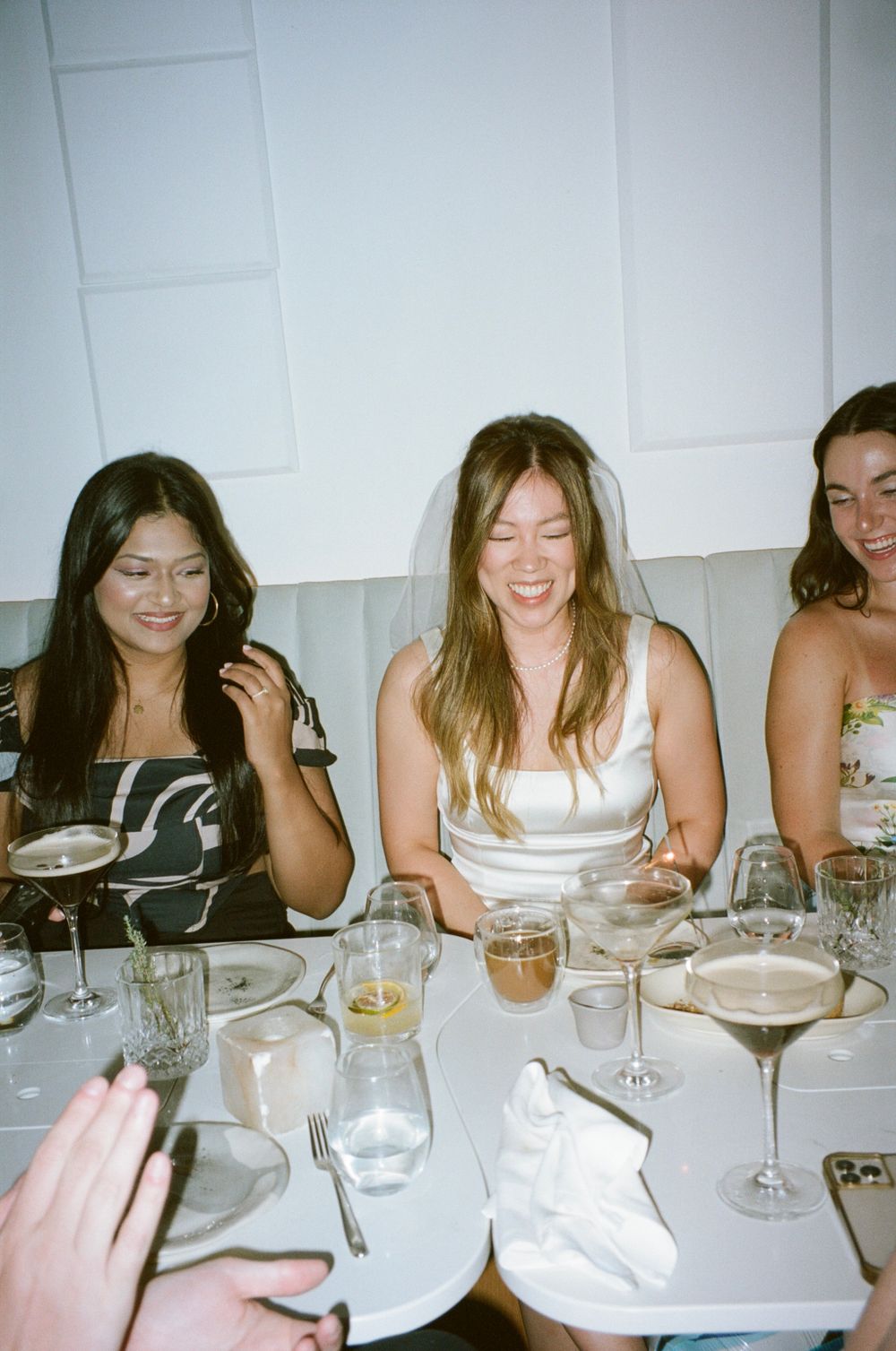 Group enjoying drinks and laughter at an elegant dinner table.