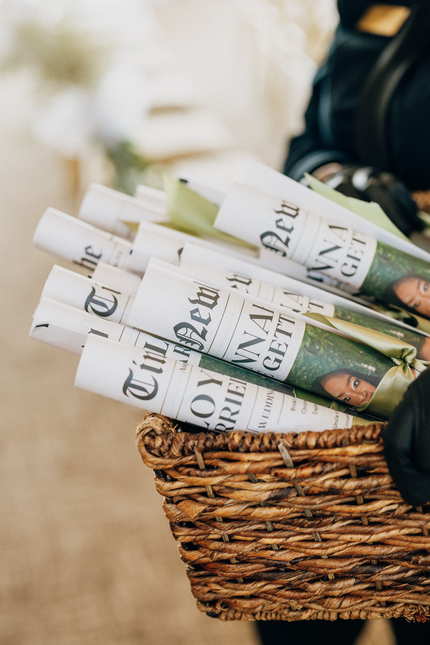 Wine bottles wrapped in white paper labels are arranged in a rustic woven basket.