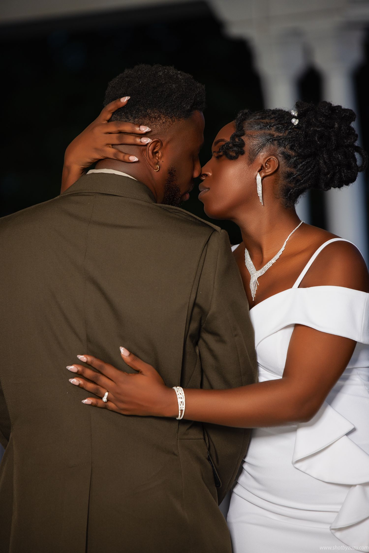 Romantic wedding portrait showing couple embracing in military dress uniform and white gown.