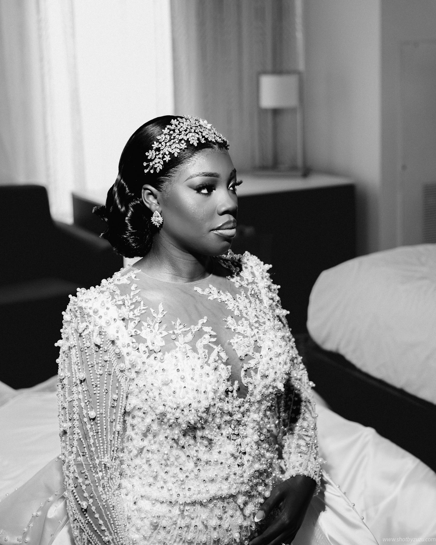 A black and white portrait showcases a bride in an ornate beaded gown and crystal headpiece.