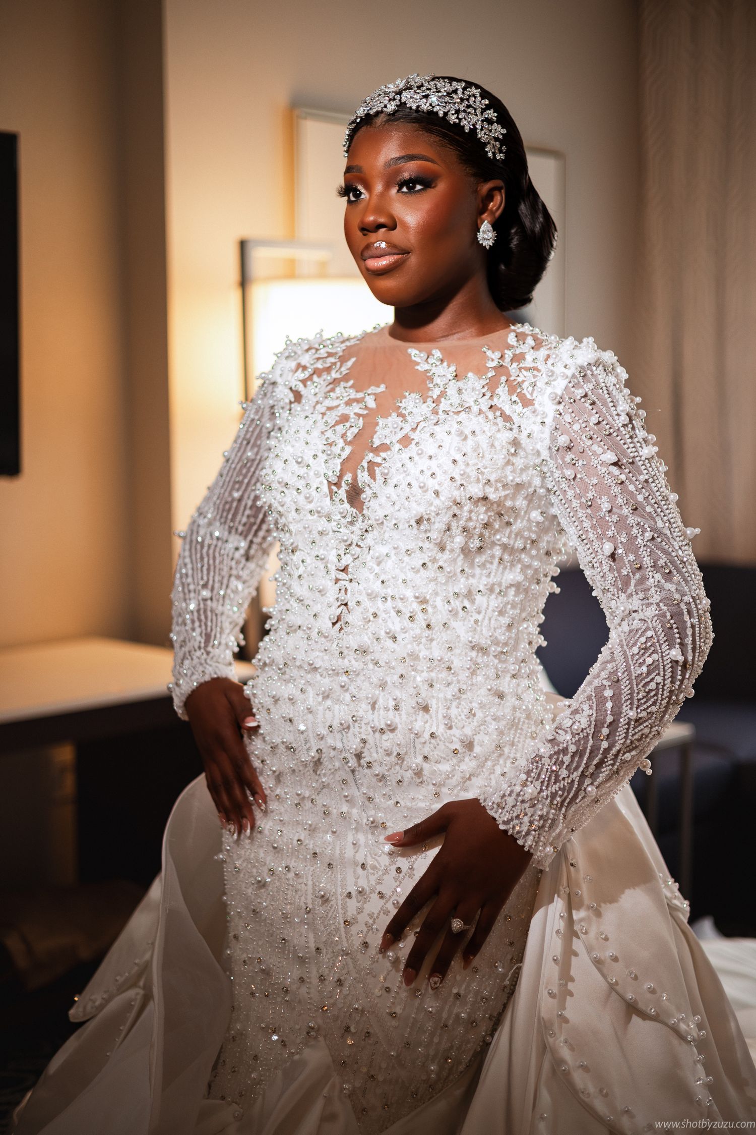 A regal bridal portrait showcases an intricate beaded gown with sheer details.