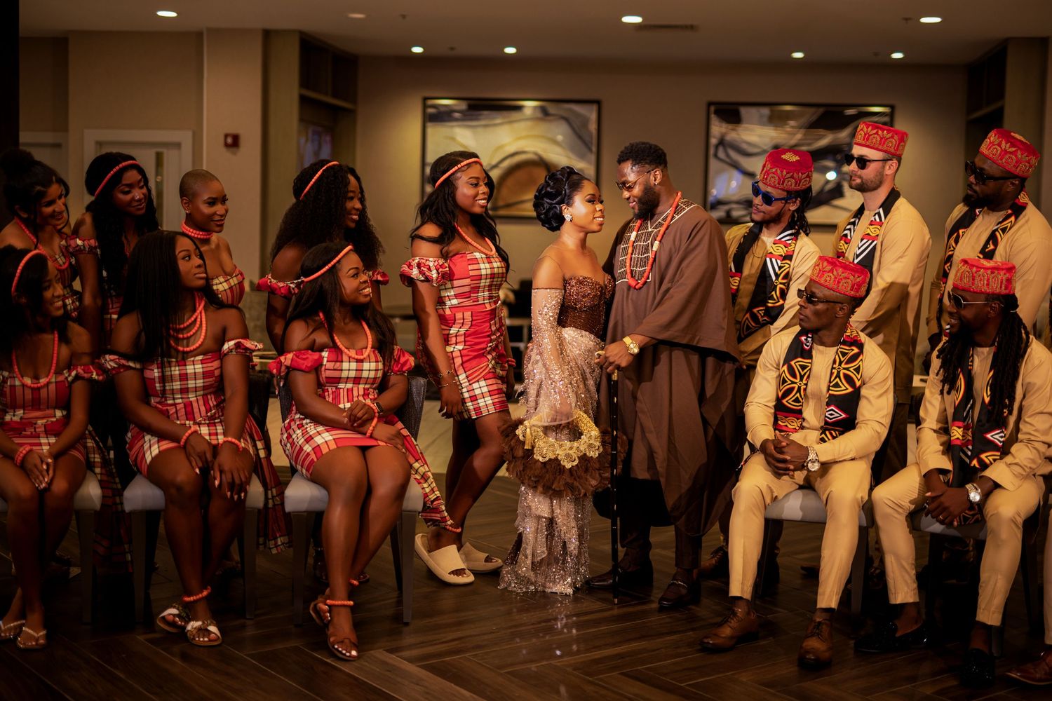 Group photo of wedding party members in traditional African and western formal attire.