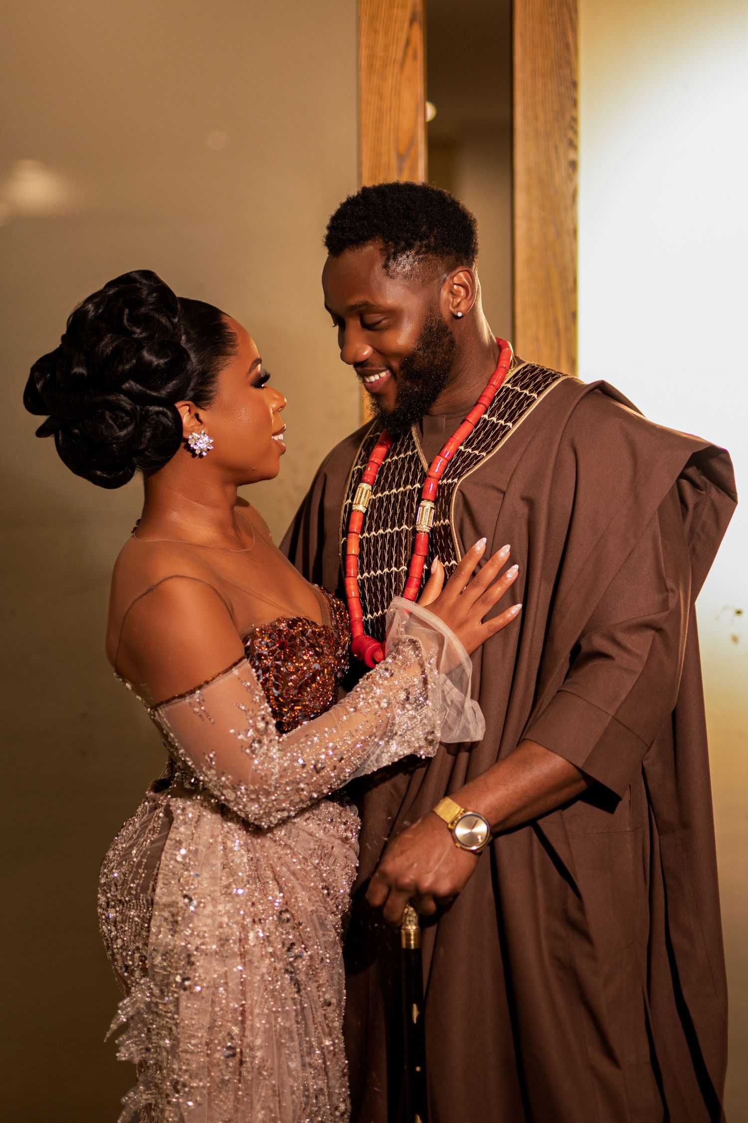 Intimate moment between couple in traditional African wedding attire.
