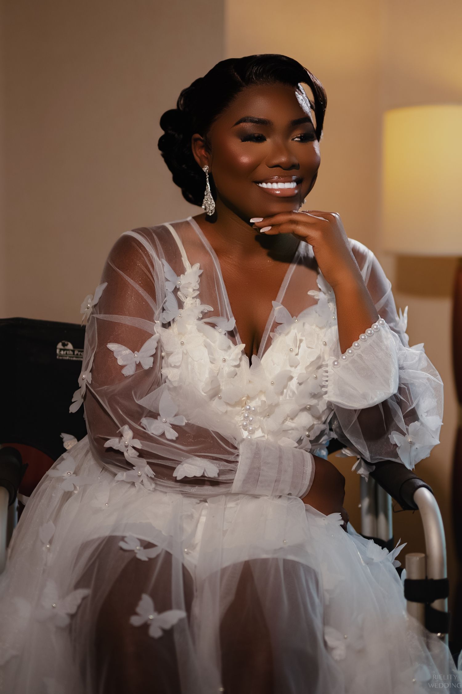 Ethereal bridal portrait in sheer butterfly-adorned dress with delicate details.