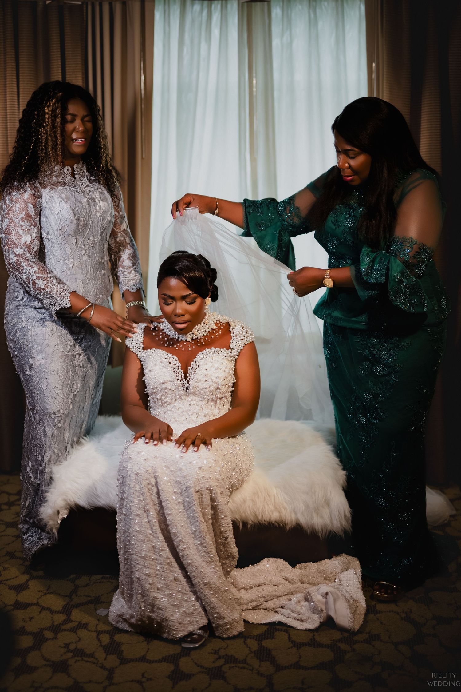 Wedding preparations show final touches being added to bride's elegant lace gown.
