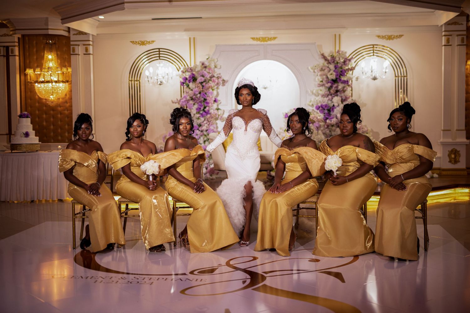 Bridesmaids in gold dresses seated in elegant formation during wedding celebration.