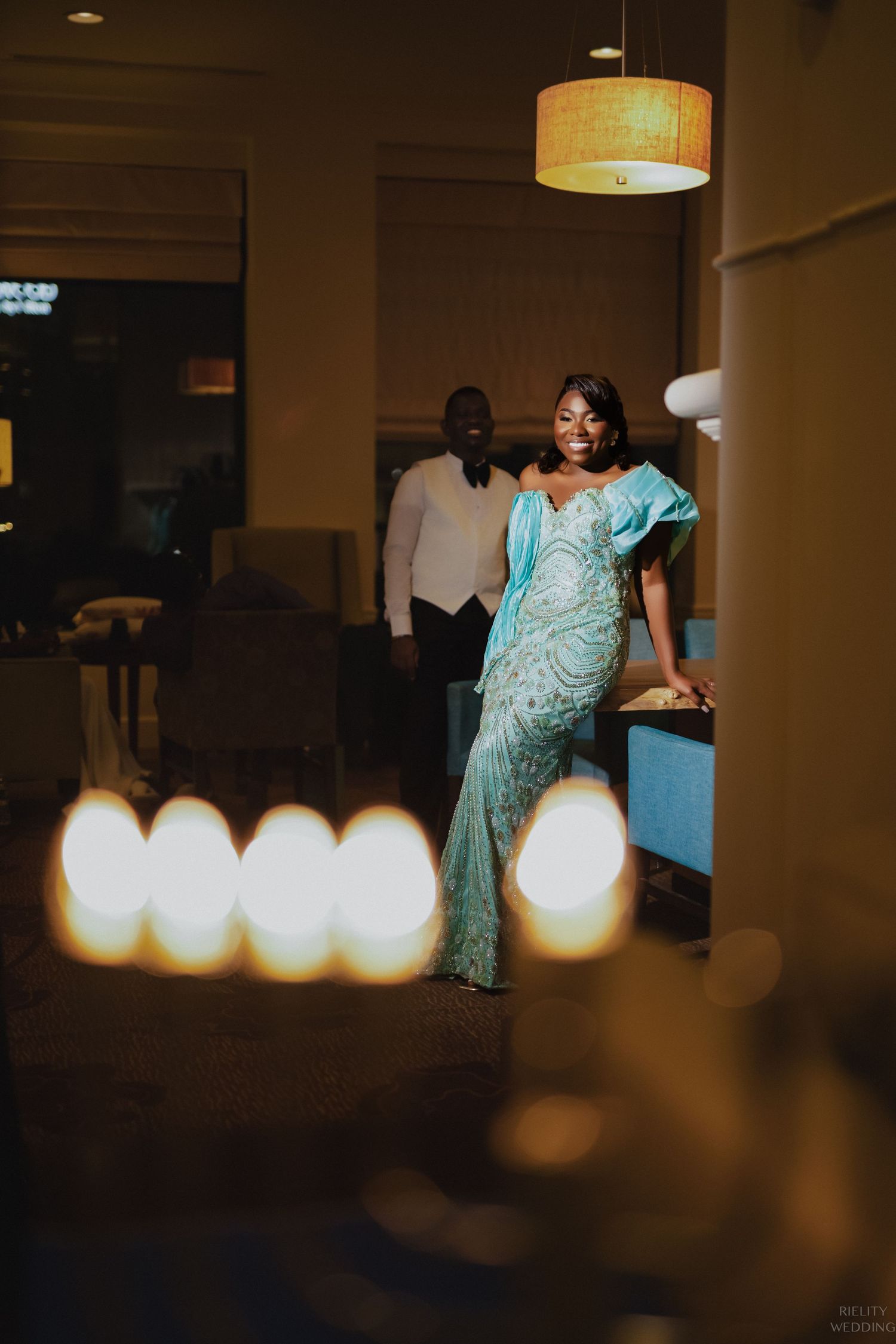 Evening portrait under warm lighting shows couple in formal attire.